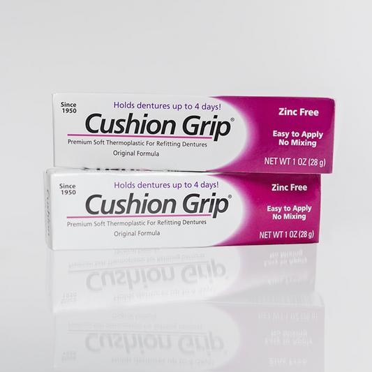 Two boxes of Cushion Grip thermoplastic denture adhesive on a white background